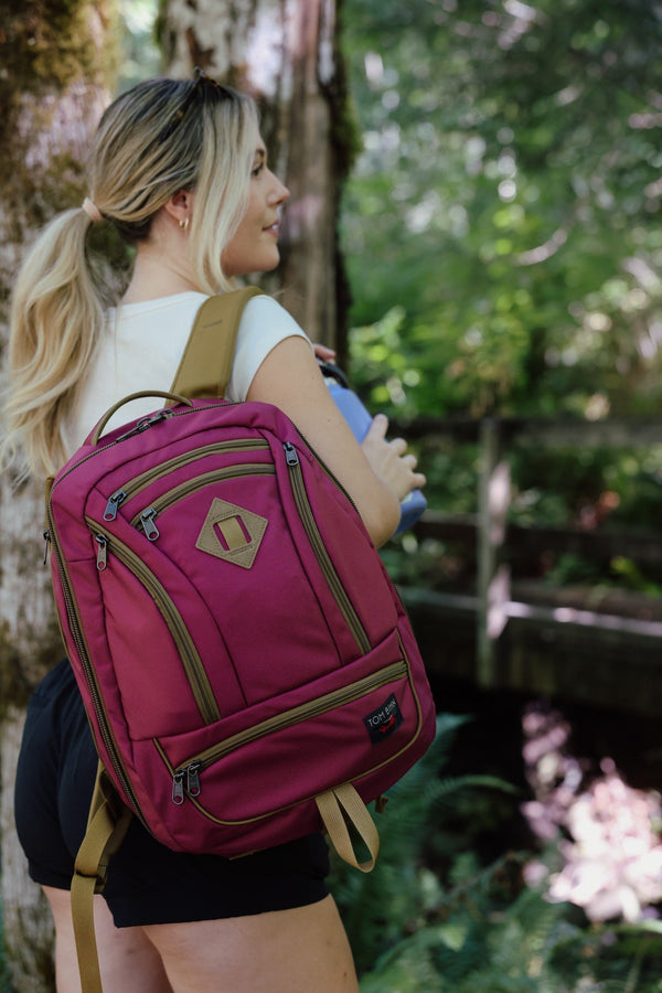 Blond female carrying a raspberry guide's edition synik 26 slung over one shoulder on a hike